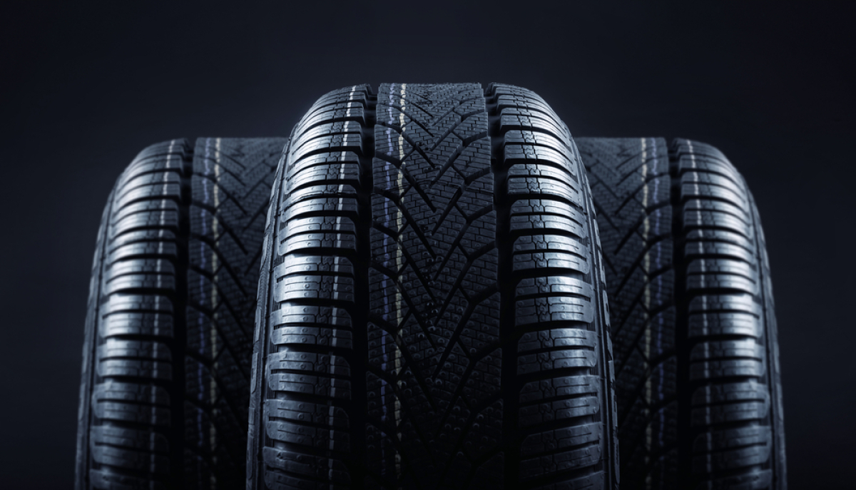 This is an image of three new black automobile tires set against a black background.