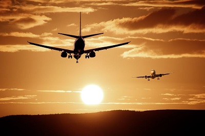 An image of airplanes crossing paths, one landing and one taking off.