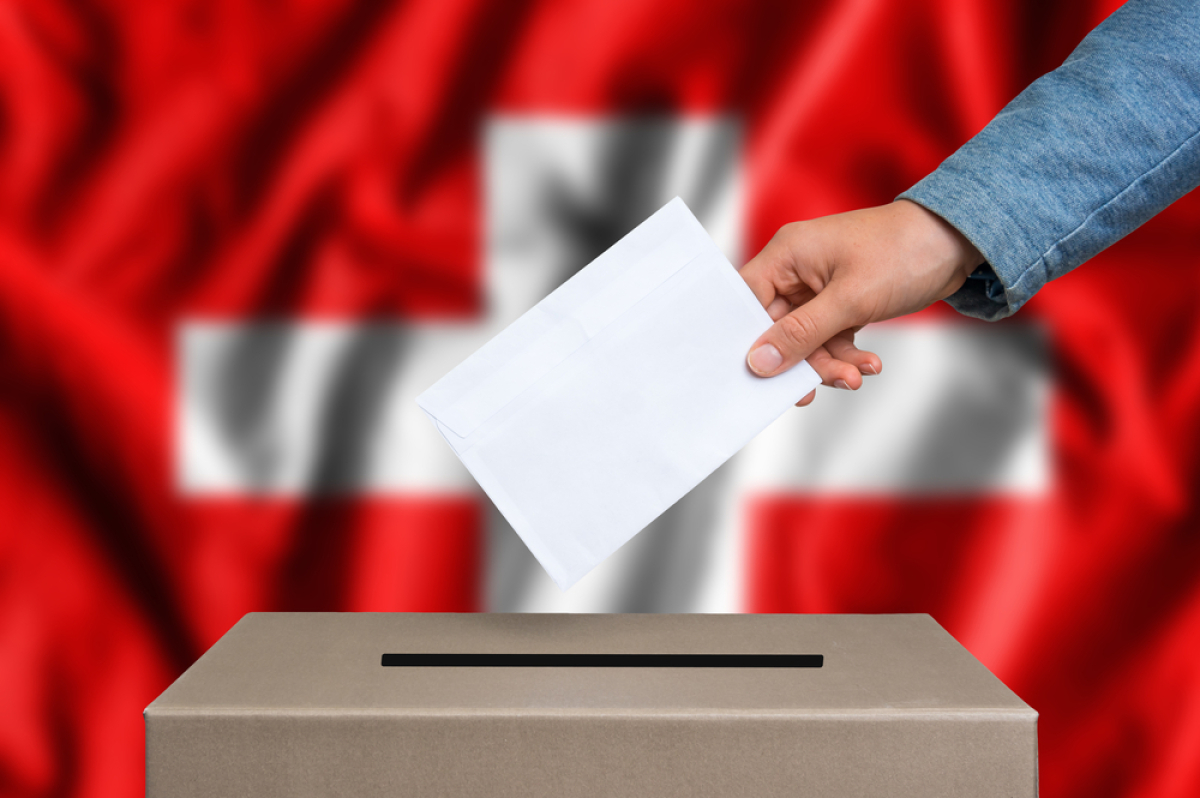 This is an image of a man placing a ballot in a ballot box.