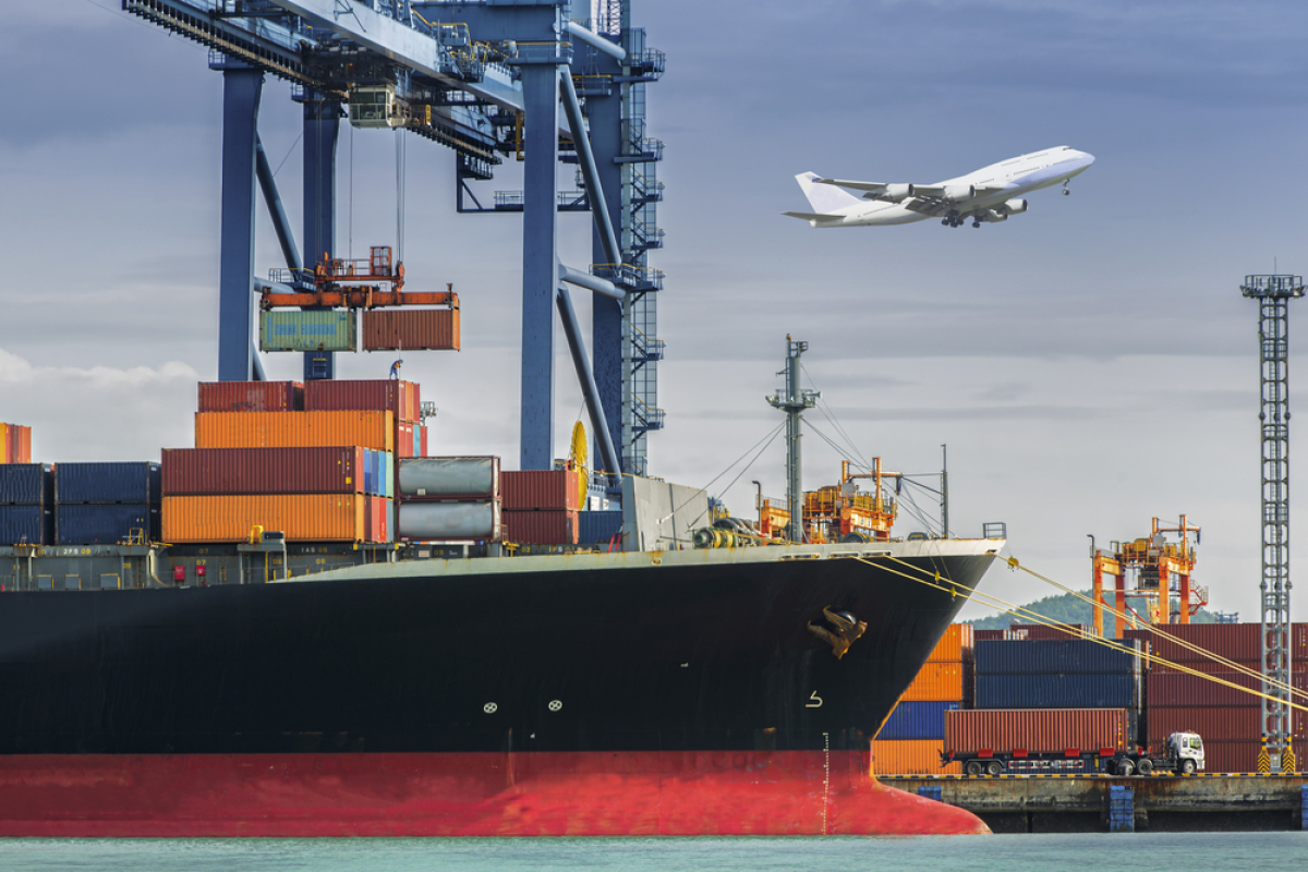 An image of a crane removing raw materials from a cargo ship.