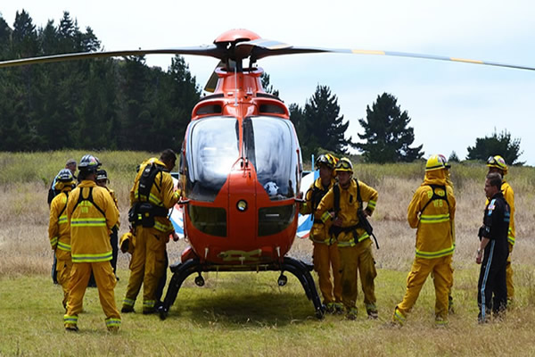 Firefighters conferring with helicopter personnel.