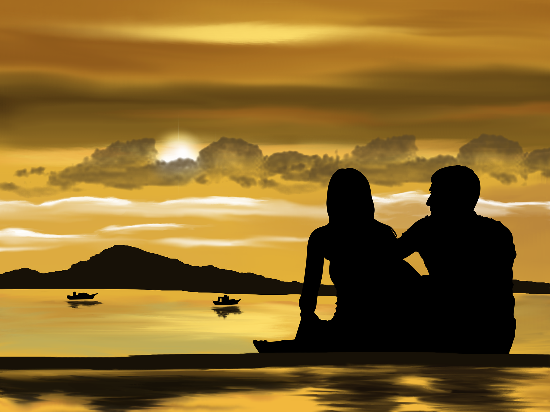 This is a photograph of a couple sitting on a beach enjoying a sunset with some boats in the water. 