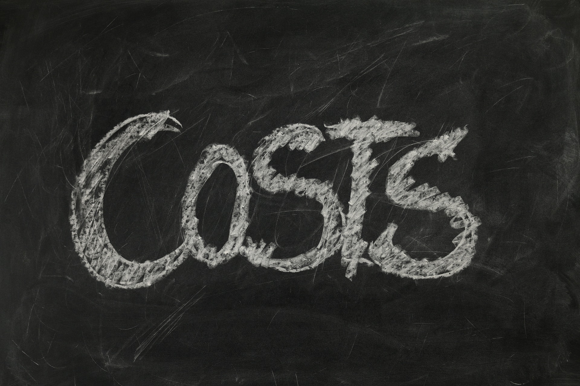 This is a photograph of a blackboard with the word ‘costs’ written on it in white chalk.