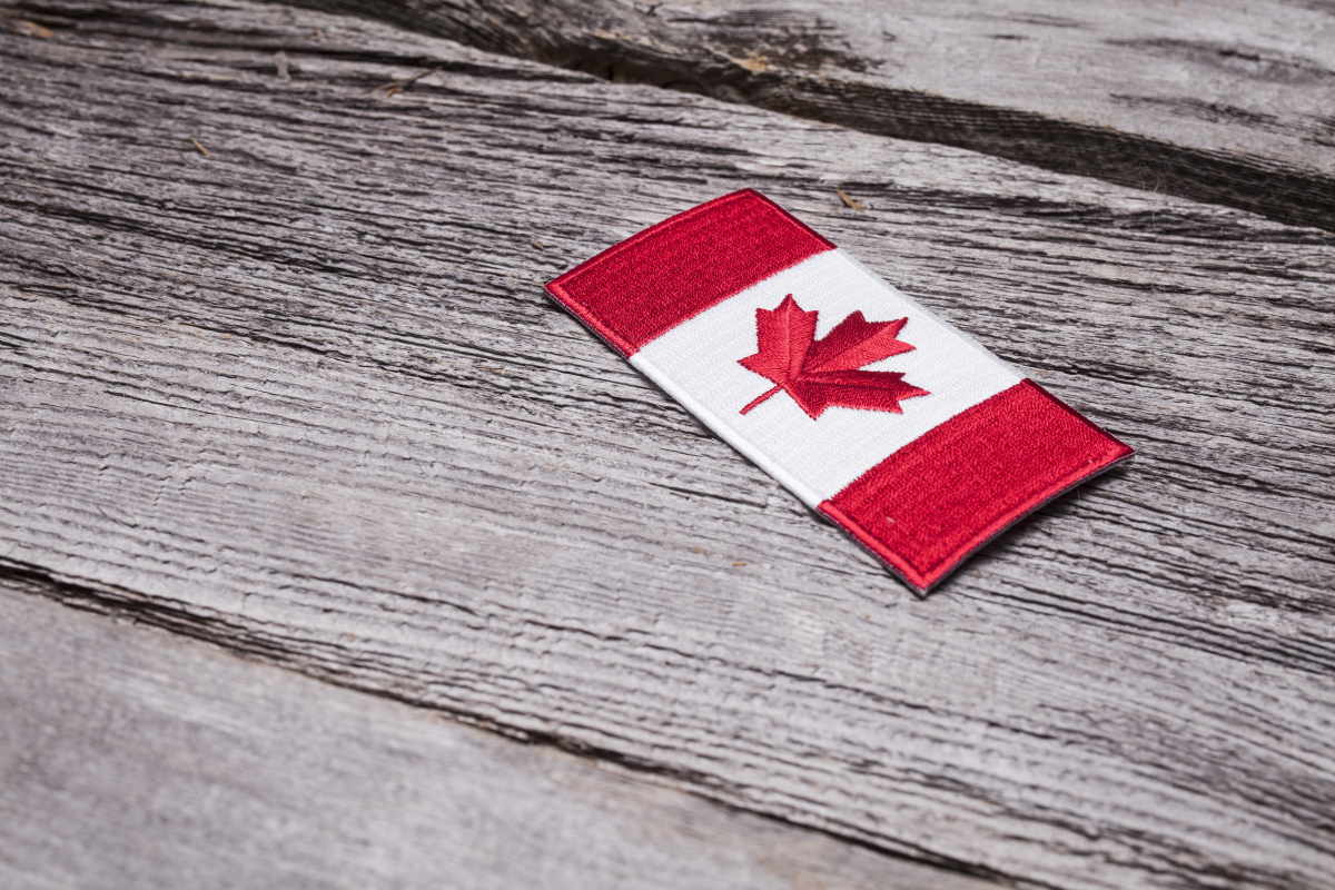 This is an image of a Canadian flag emblem on a piece of wood.