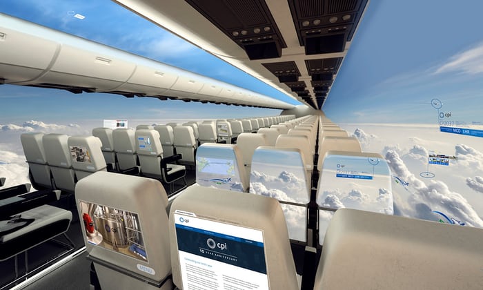This is an artist’s rendering of a airplane looking forward within the passenger cabin. The walls have been replaced with full length screens that show the clouds and locations of different cities.