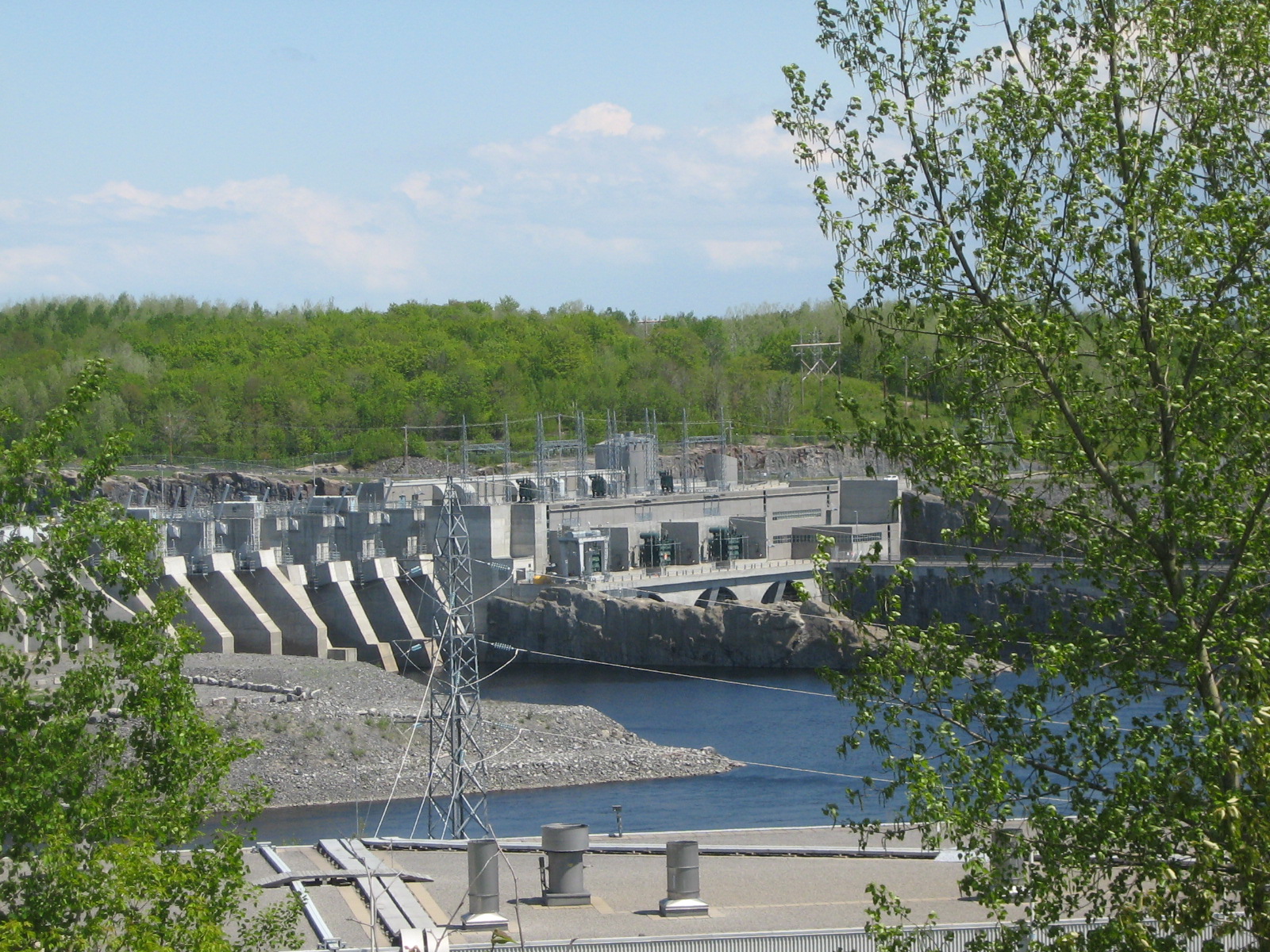 A large hydroelectric plant is situated next to water.
