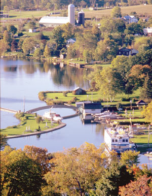 This is a colour aerial photograph of a small Ontario town showing a lake, boats and small houses.