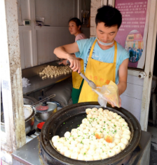 a server is placing dumplings in a bag.