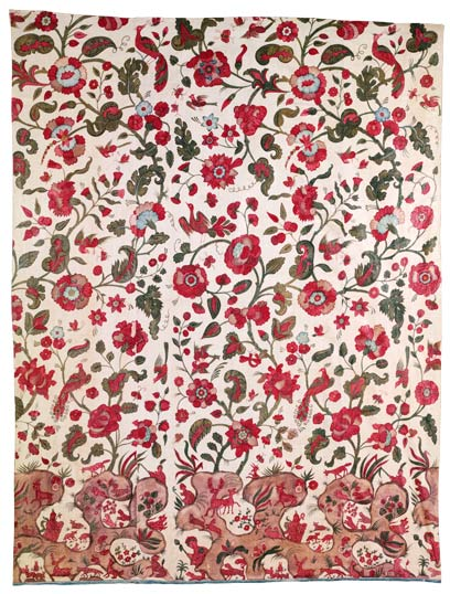 This is a white cotton cloth printed with a variety of red flowers and green leaves and vines.