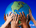 This is an image of a globe.  There are several hands holding up the globe.