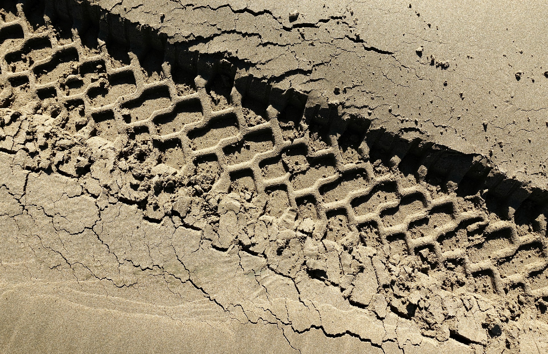 This is a close up image of a tire track in the dirt.