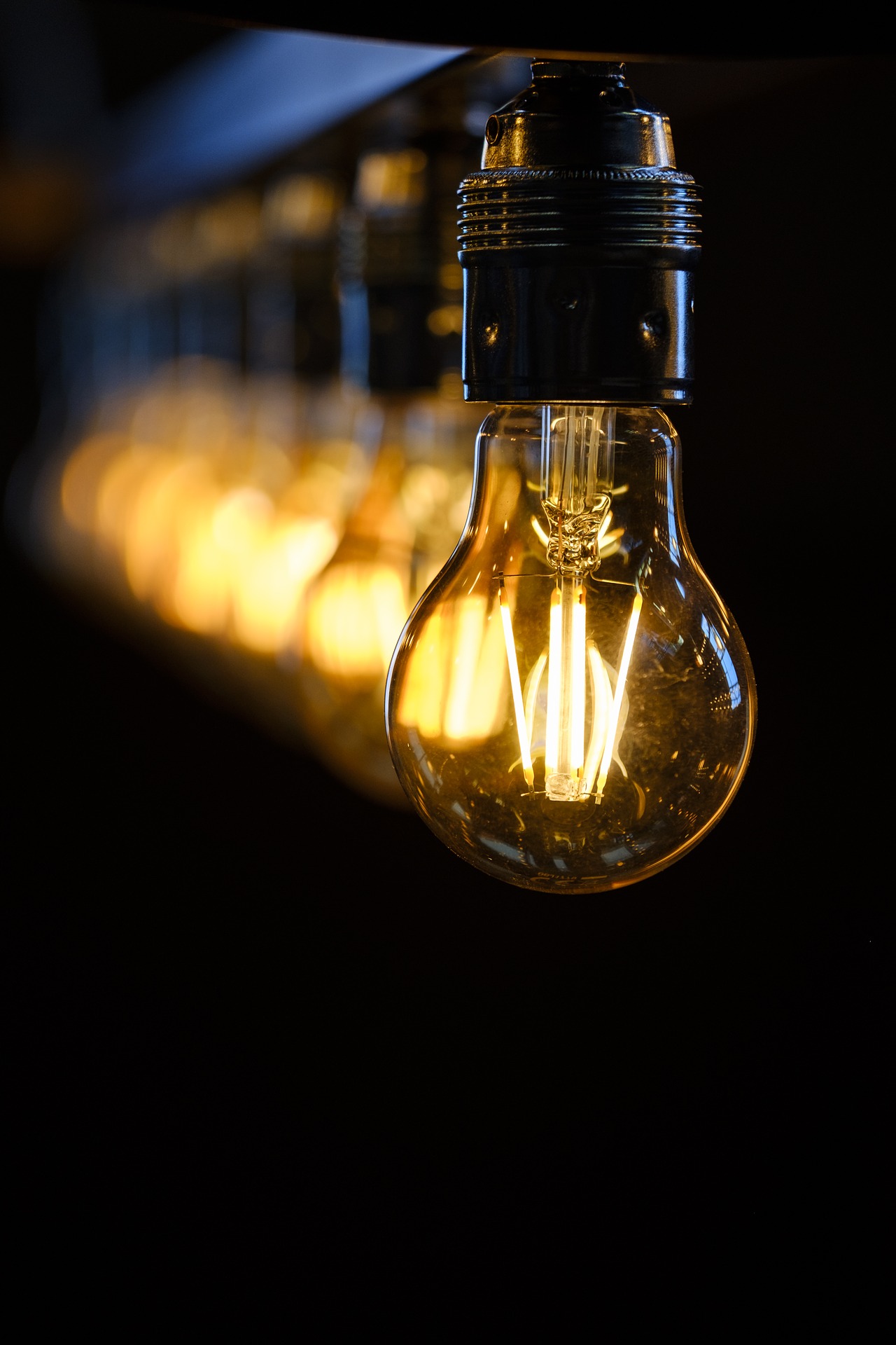 This is an image of a row of lit light bulbs hanging from an unseen ceiling.