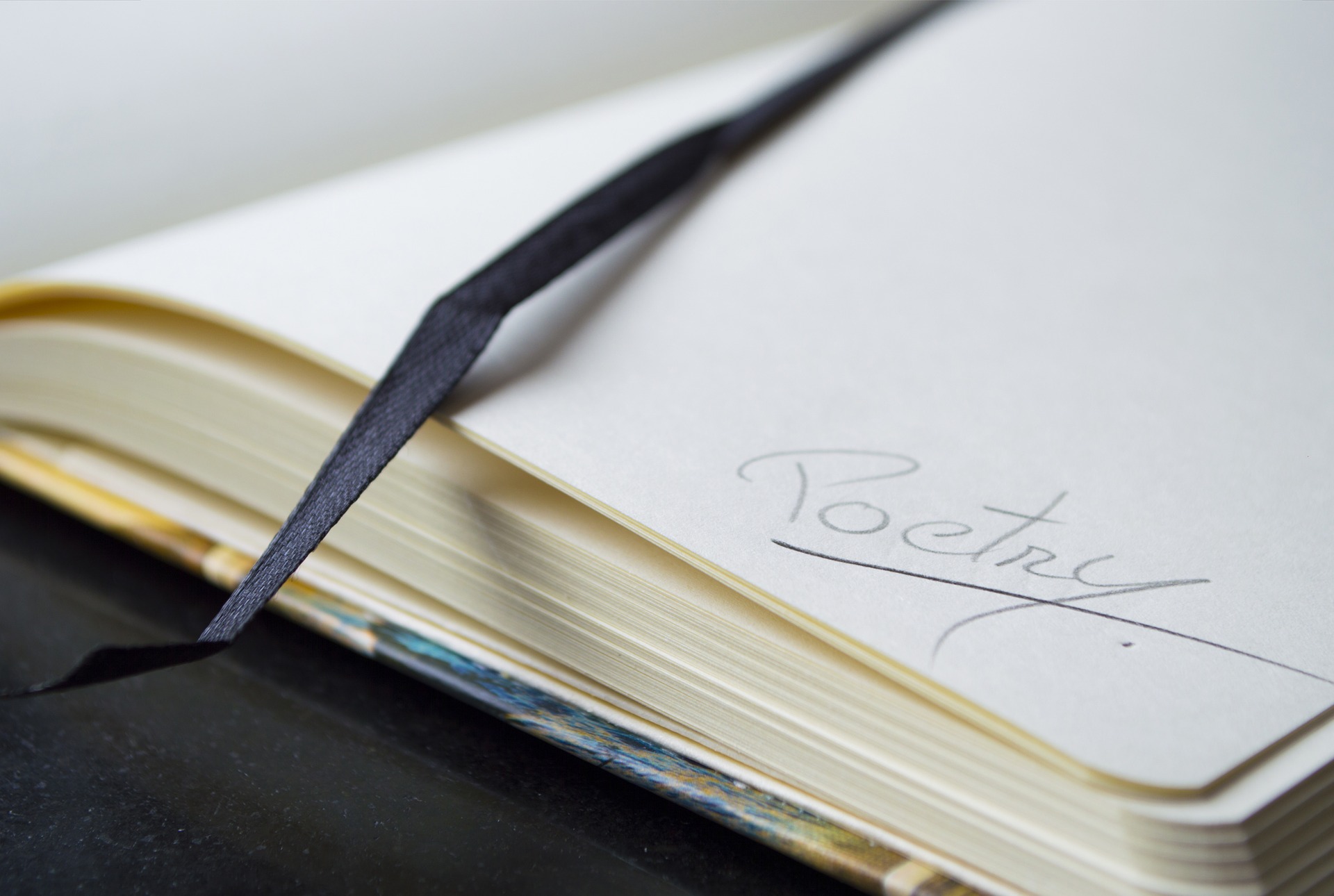 This is an image of a notebook with the word, Poetry, written on the bottom right corner.