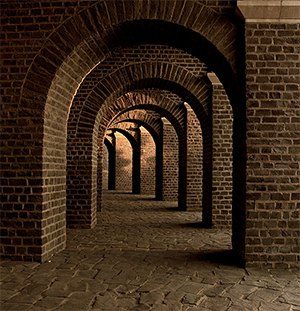 This is an image of a vaulted cellar with brick archways receding into the distance.