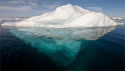 This is an image of an iceberg showing the majority of it hidden under water.