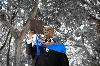 This is an image of a smiling graduating student clad in his gown. He is about to throw his cap in the air.