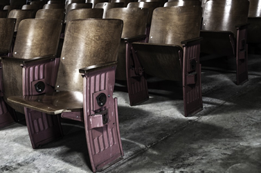 This is an image of rows of metal theatre seats on concrete.