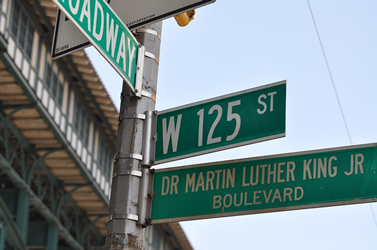 This is an image of street signs that read &lsquo;W 125 ST&rsquo; and &lsquo;Dr Martin Luther King Jr Boulevard.&rsquo;