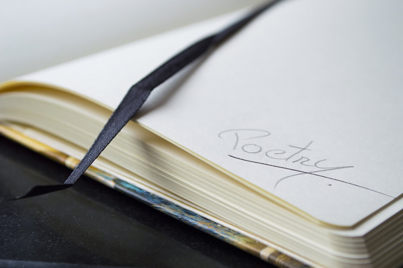 This is an image of a blank journal with the word “Poetry” written in the right hand corner.