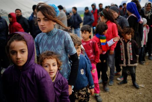 Des enfants refugies font la queue pour se nourrir.
