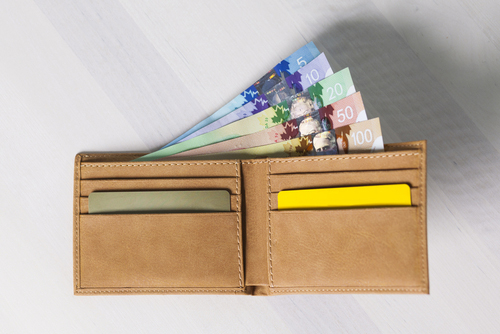 This is an image of a wallet with bills fanned out of the billfold.