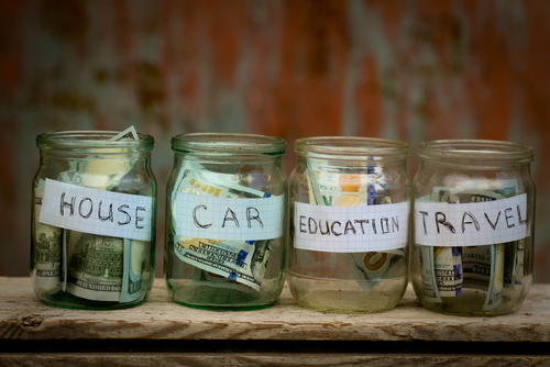 This is an image of a series of jars of money with labels for House, Car, Education and Travel.