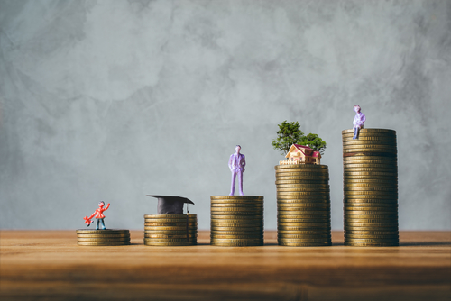 This is an image of a series of stacks of coins with figures on each stack representing a different stage of life.