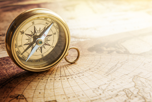 This is an image of a map of the world and a compass.