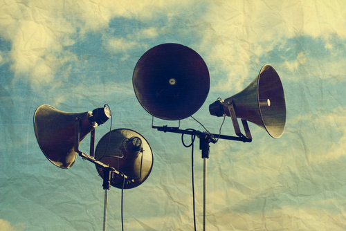 This is an image of a loudspeakers framed against the sky.