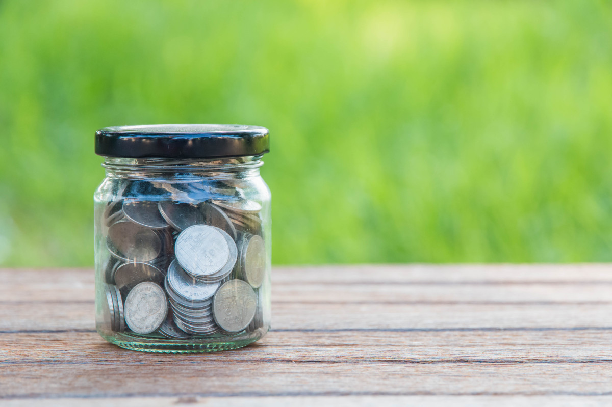 This graphic shows a glass jar filled with money.