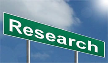 This is an image of a green street sign containing the word, “Research.” The sign is set against a blue sky background.