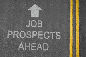 This is image of an aerial view of a small portion of paved road with the phrase “Job Prospects Ahead” painted on it.
