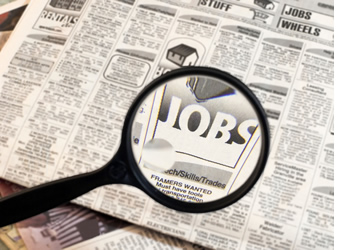 This is an image of a magnifying glass focusing in on the Jobs section of a newspaper.