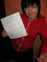 This is an image of a young person smiling and proudly holding up and showing their resume.