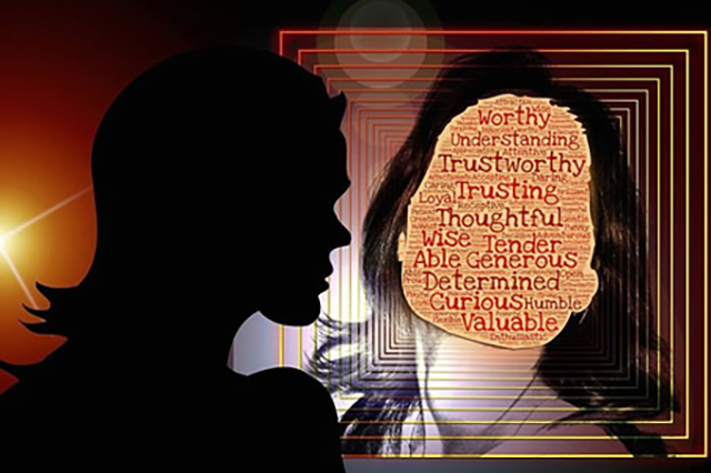 This is a graphic image of the sihouette of a person looking at their image in a mirror and instead of seeing their face they see personality traits such as understanding, trustworthy, loyal, thoughtful, wise, tender, etc.