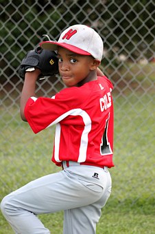 This is a young boy, wearing a baseball uniform in a pitcher’s stance.