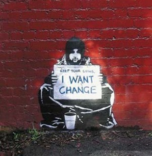 This is a picture of graffiti painted on a brick wall of a homeless man sitting cross-legged on the sidewalk. His sign says Keep your coins, I want change.