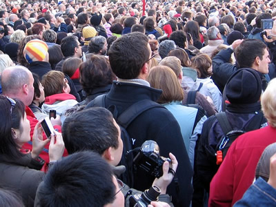This is a photograph of a crowd of people watching something in the distance.