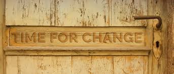 A wooden door with a simple metal handle which reads 'Time for Change'