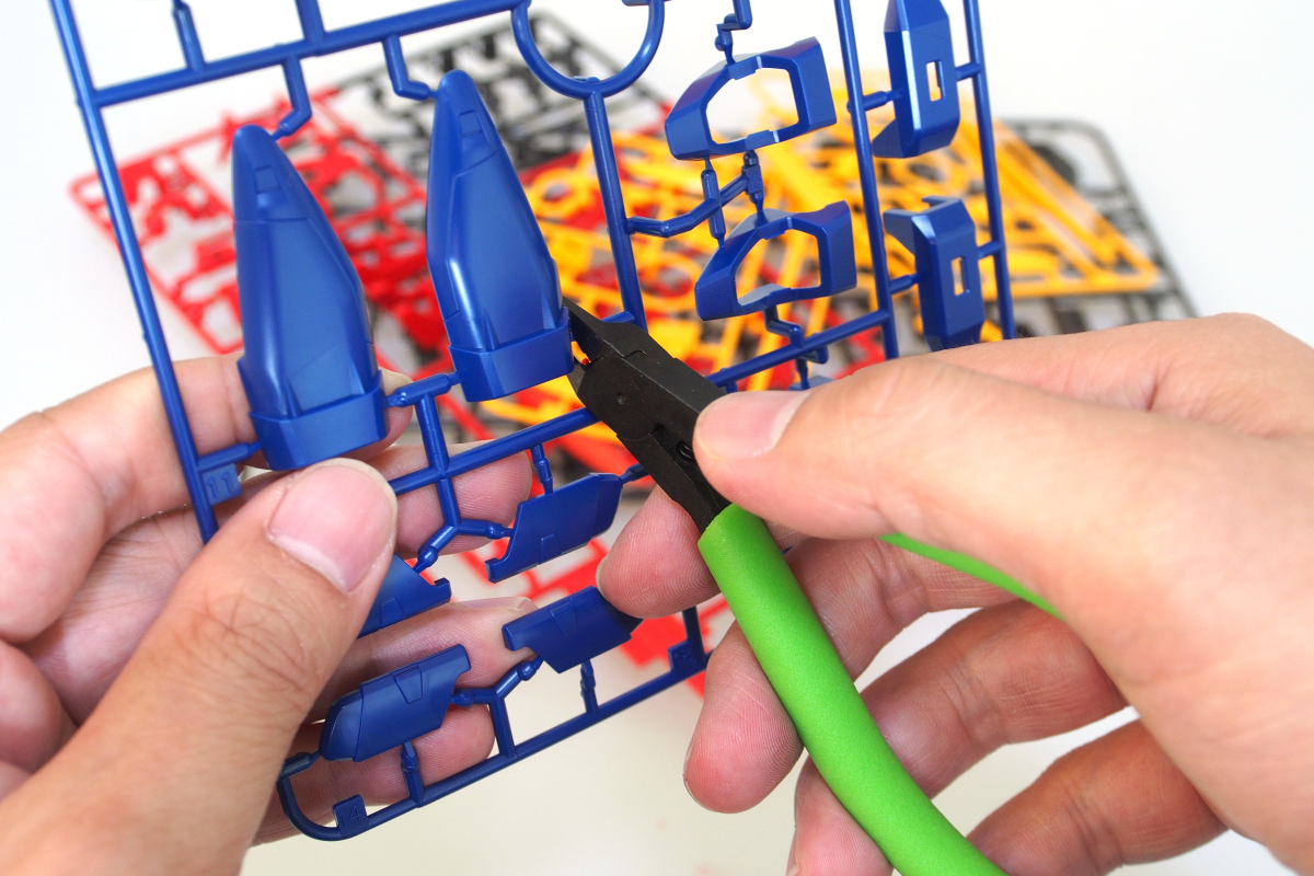 This is an image of a person who is using a tool to cut the pieces of the model out of the plastic frame that holds them. 