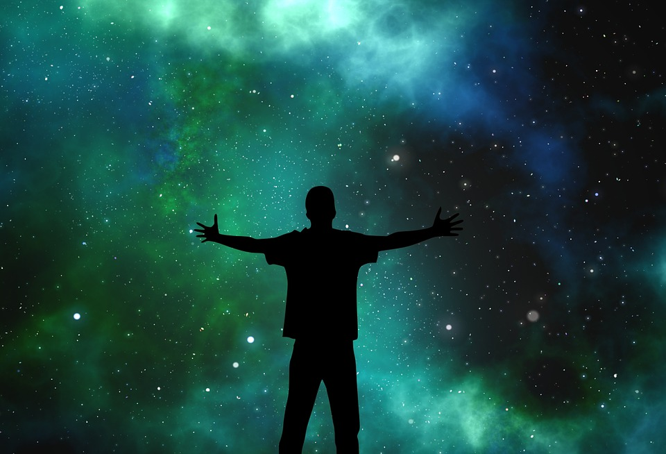 This is an image of a person in silhouette against a backdrop of a starry sky.