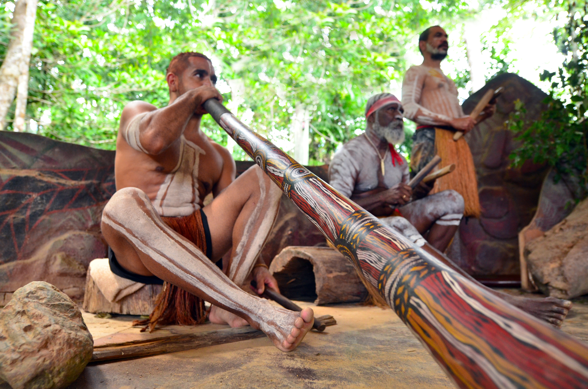This is an image of Yirrganydji Aboriginal men playing Aboriginal music on the didgeridoo and other wooden instruments.