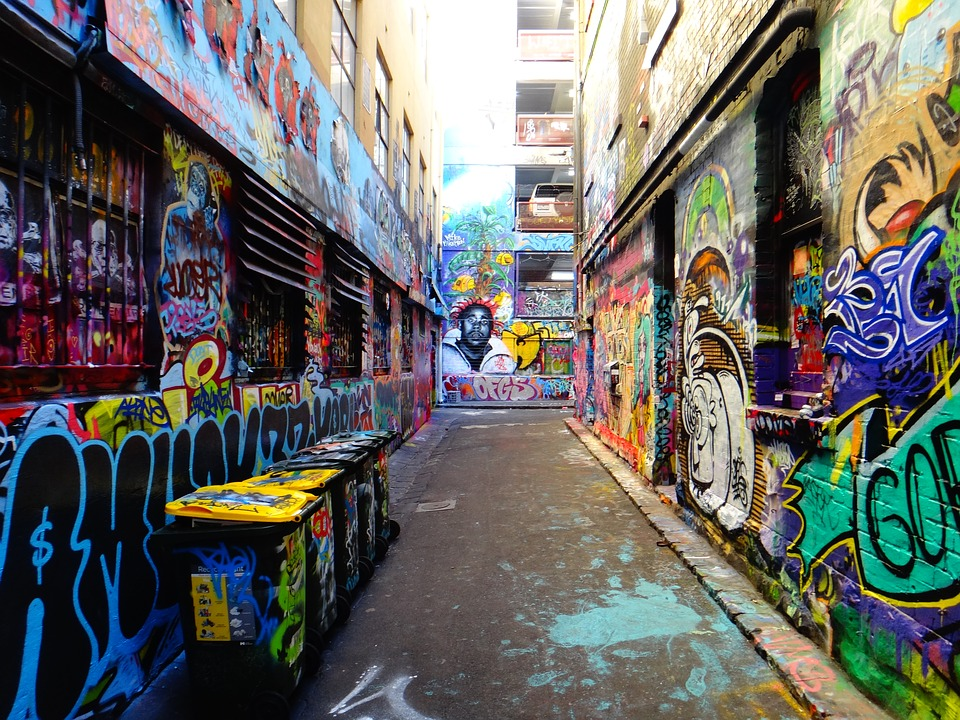 This is an image of an alleyway, covered in brightly painted graffiti.