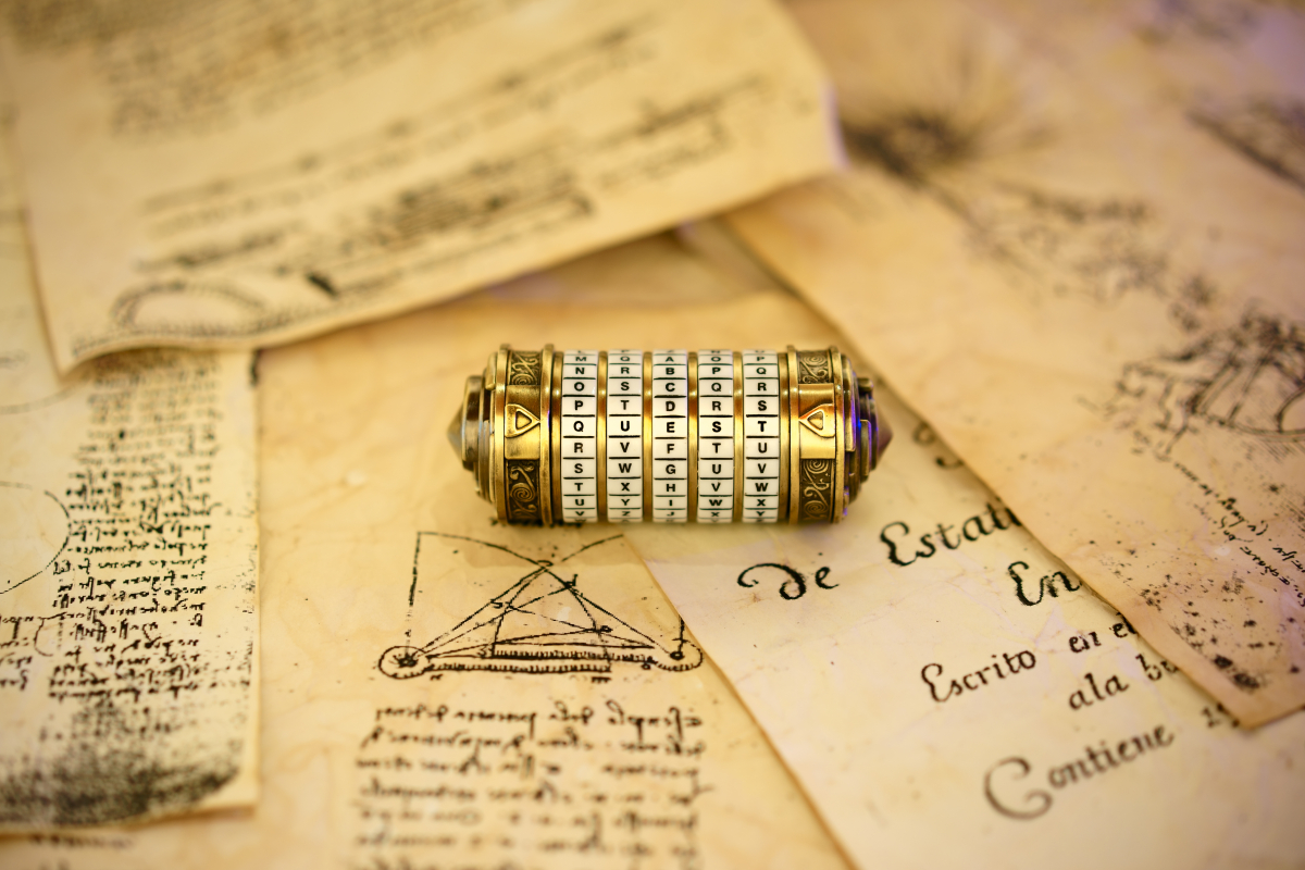 This is an image of old combination roll lock that uses 5 letters. It is sitting on some old paper with caligraphic writing. 