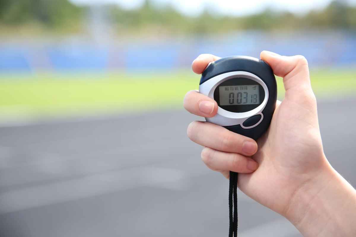 This is an image of a person's hand holding a running stopwatch.