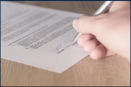 This is an image of someone signing a contract.
