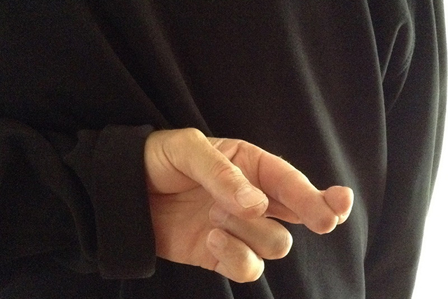 This is an image of someone with their fingers crossed behind their back.