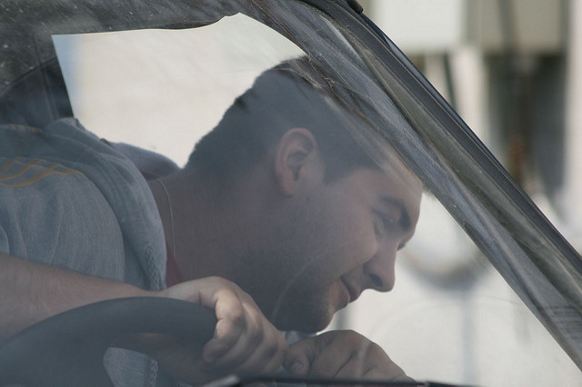This is an image a man getting into a car for a test drive.