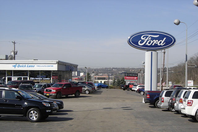 This is an image of a car dealership with many cars in the lot.