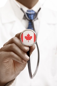 This image shows a doctor holding a stethoscope with a Canadian flag printed on the bottom of the stethoscope.